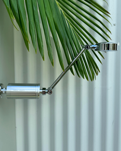 Silver shower filter attached to a high-rise S-shaped shower arm.